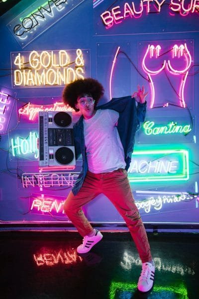 pared de neon con chico con un loro en el hombro